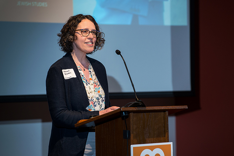 Hannah Weisman, executive director of The Magnes Collection of Jewish Art and Life speaks at a microphone at a conference.