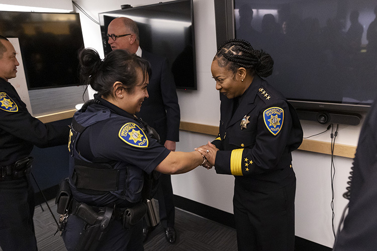 One of UCPD's female police corporals greets the new police chief after the swearing-in ceremony, and they shake hands.