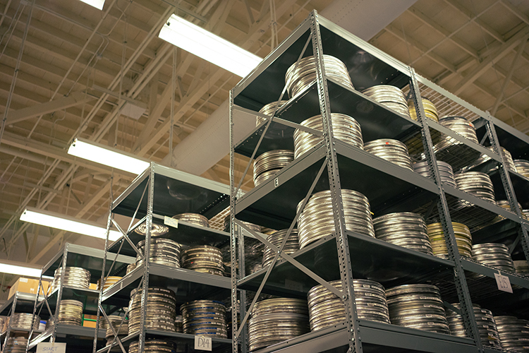 Stacks of 35mm films are stored in steel film cans; the 16 mm ones in the vault often are in colorful film cans.