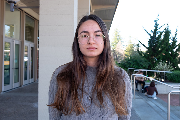 Meltem Su, president of the Turkish Student Association, poses for a photo. She is looking straight at the camera and not smiling. She's wearing wire rims.