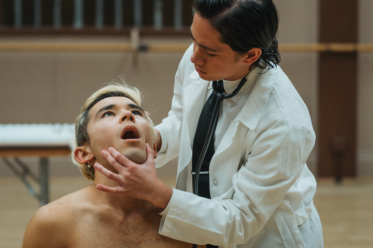 a person dressed as a doctor examines a person's mouth