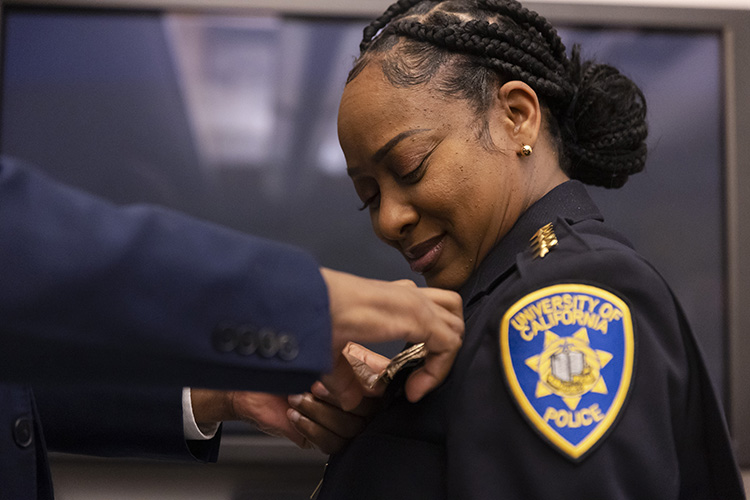 A badge is pinned onto the uniform of Yogananda Pittman, UC Berkeley's new police chief.