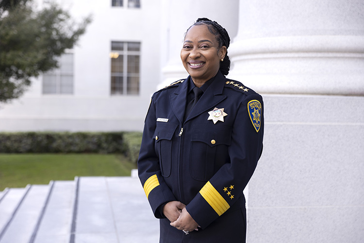 Yogananda Pittman, wearing a UCPD uniform and smiling wide, stands for a portrait outside Sproul Hall before her swearing-in ceremony as UC Berkeley's new police chief on Feb. 1, 2023.