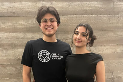 Students Egbert Villegas and Nelly Elahmadie, both wearing black T-shirts, pose for a photo at the Chris Kindness Award ceremony at Berkeley Haas, where Villegas was given the March 2023 Chris Kindness Award.