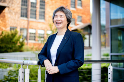 Dean of UC Berkeley's College of Engineering, Tsu-Jae King Liu poses in a courtyard wearing a blue blazer and smiling