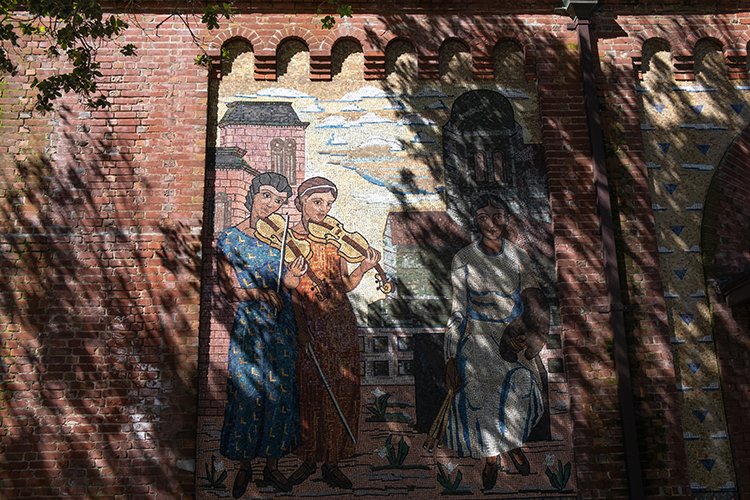 Two violinists are depicted in a mosaic mural on the Old Art Gallery building