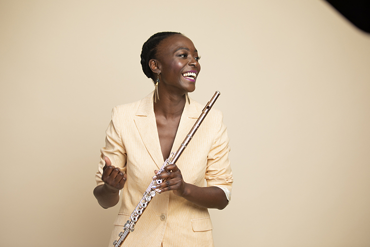 Musician holds a flute and smiles