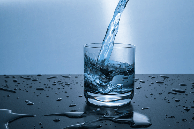 A photo of water pouring into a drinking glass
