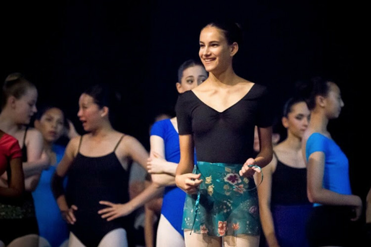 a young Vera surrounded by other girls doing ballet