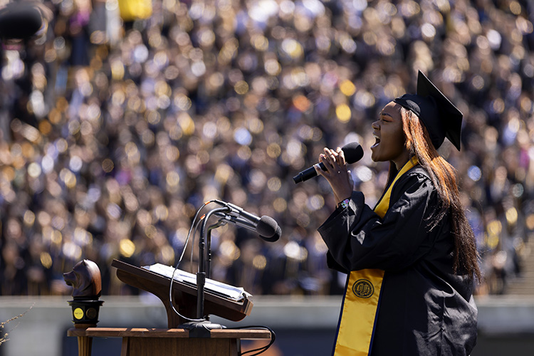 A graduate sings from a podium