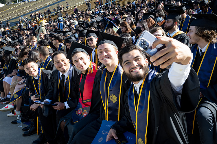 A group of graduates take a selfie in the stand during commencement on Saturday.