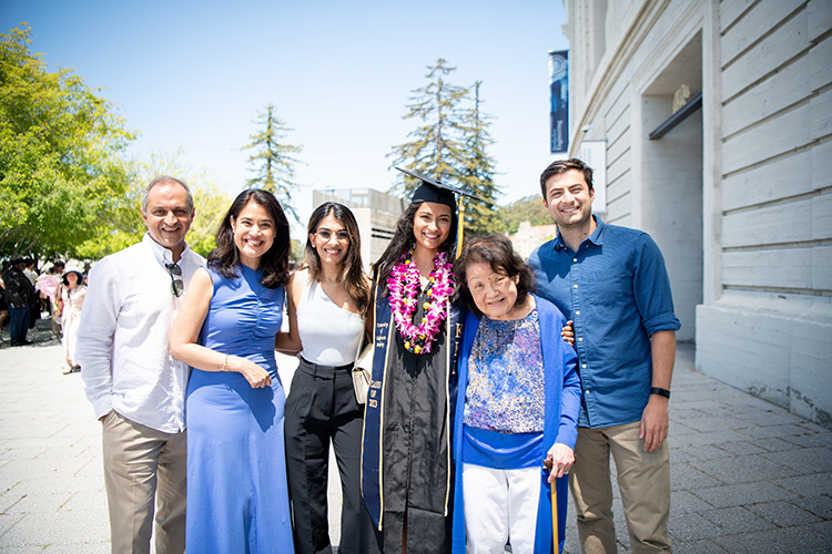 A family and their graduate pose outside of Memorial Stadium at Saturday's commencement