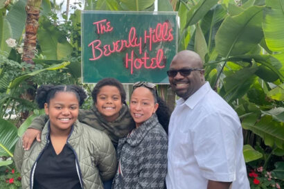 four people smiling for photo in front of Beverly Hills Hotel sign