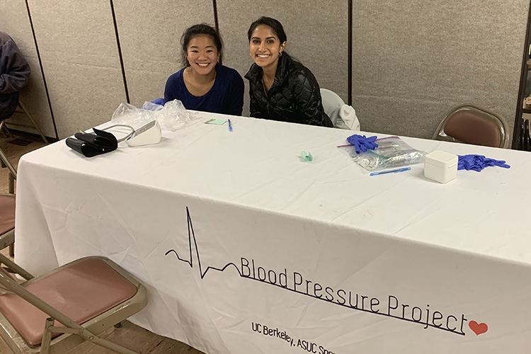 Ria Sood sitting at a table for her blood pressure project clinic