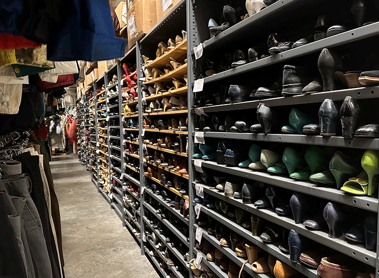 A photo shows racks of different types of shoes that are stacked floor to ceiling along the wall of a large storage room.