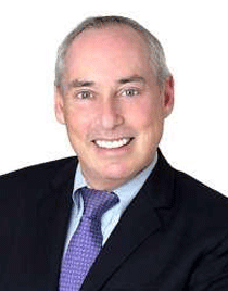 headshot of Dan Schnur, UC Berkeley lecturer in political science, wearing a dark suit, pale blue shirt and lavender tie agains a white background