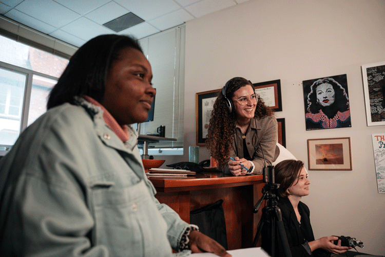 Three Berkeley Law students, from left: Chantel Johnson, Paloma Sat-Vollhardt and Dan Hilborn are in an office, apparently looking at a screen, as they work on a video requesting clemency for a longtime client facing execution. All three students are working with the Human Rights Center. (Photo by Darius Riley)