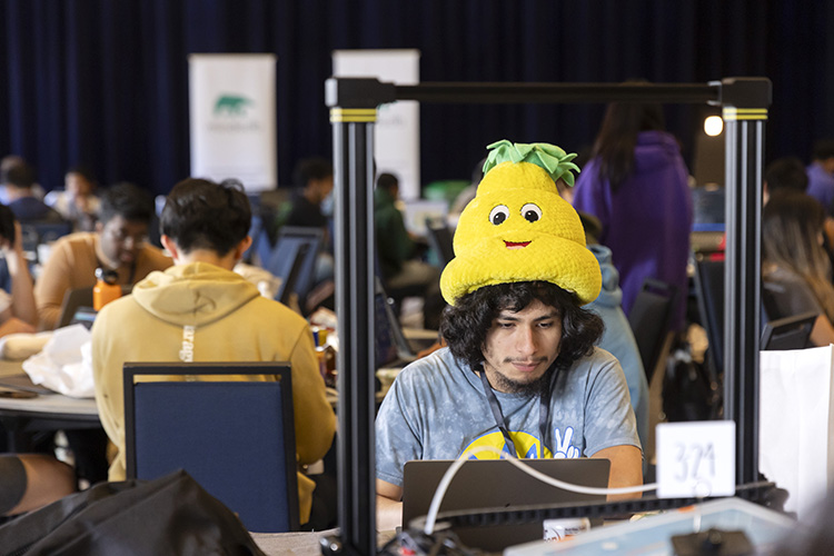 A hacker wearing a funny fruit hat that is yellow.