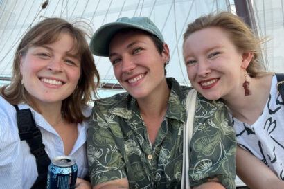 three people on a boat smile happily for the camera