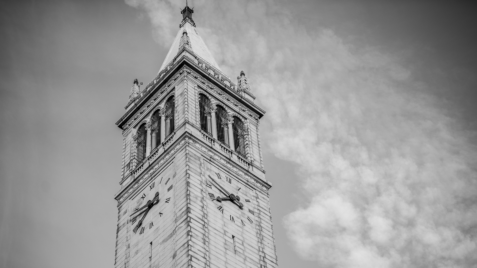A black and white photo of the top of the UC Berkeley campanile, taken from the ground.