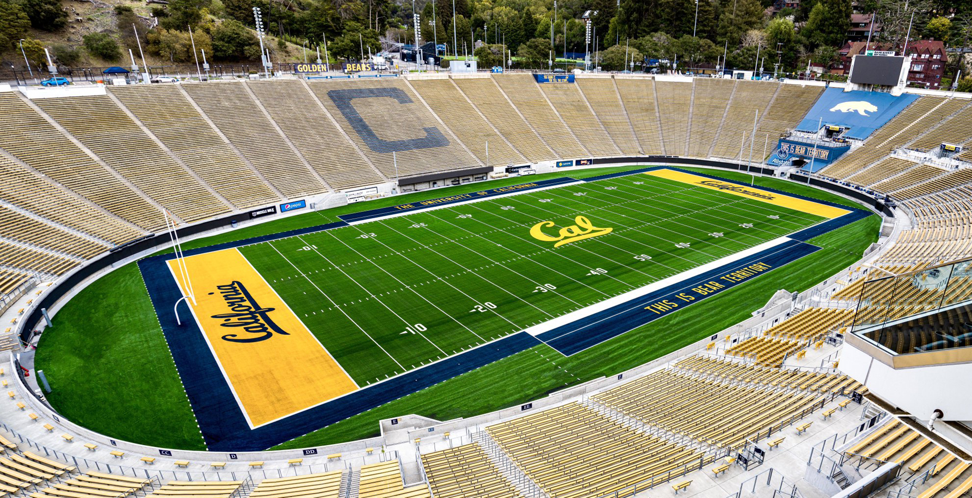A wide shot photo of the Cal Memorial Stadium with vibrant green colors of the field and completely empty.