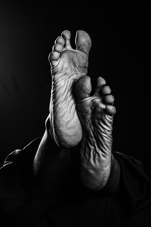 A black-and-white photo of the soles of a person's feet