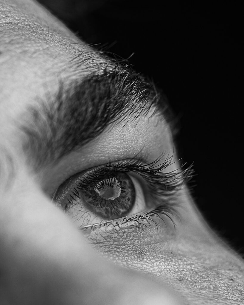 A black-and-white photo of a person's eye and eyebrow