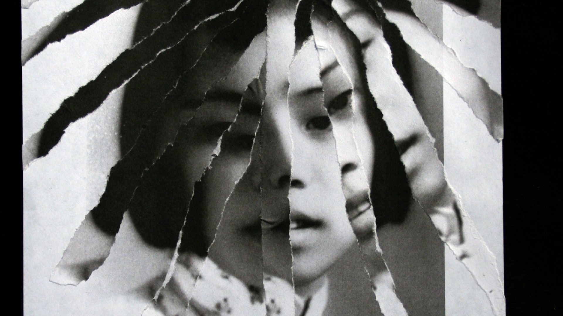 black-and-white image of a person's face with paper torn to create a collage