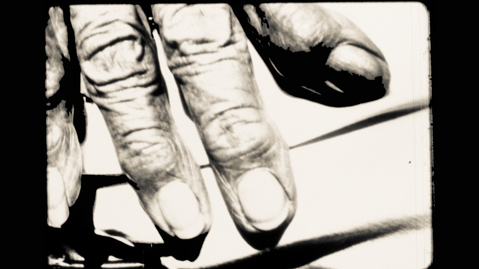 An up close black and white photo of four fingers of a hand