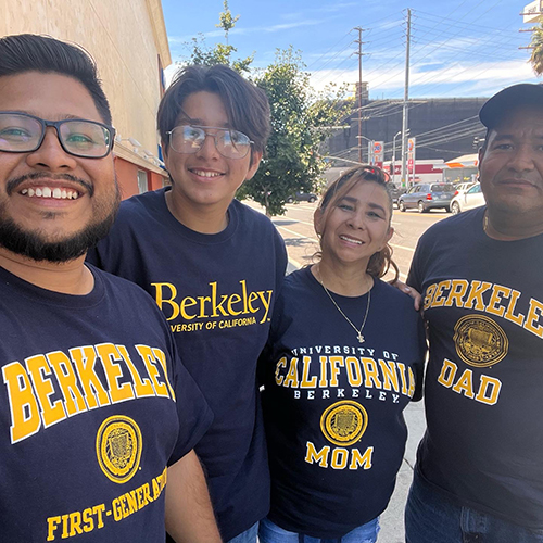 A Salvadoran family smiles and poses together outside, all wearing UC Berkeley t-shirts