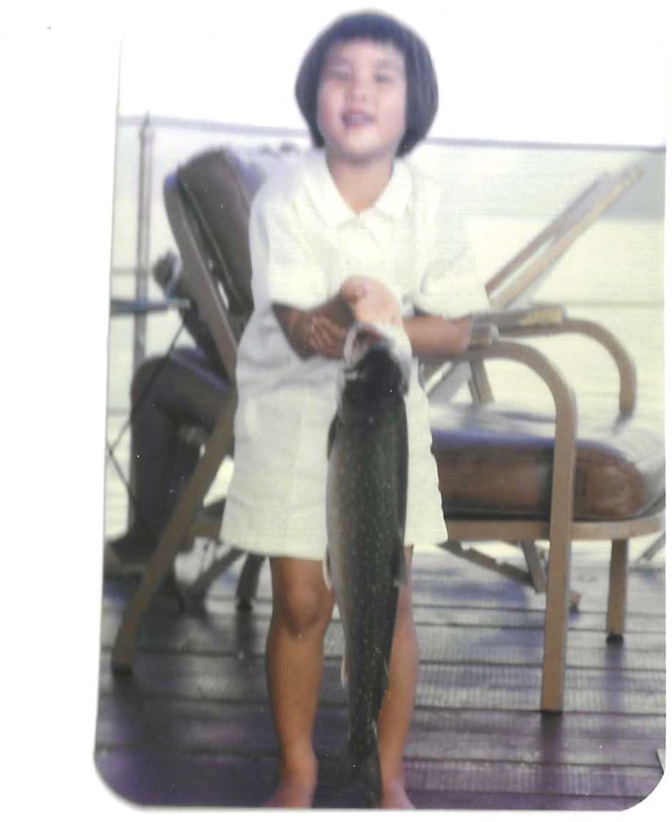 Photo of Mimura as a child after catching a fish in Idaho.