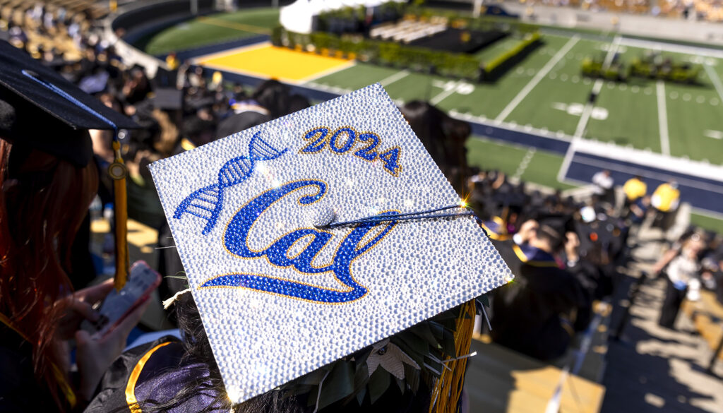 A mortarboard decorated with Cal logo, 2024 and a figure of DNA