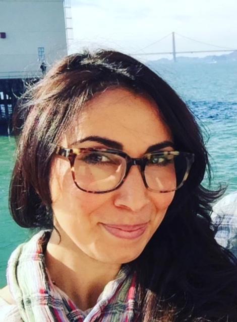Headshot of Martha Velasquez wearing glasses by the coast.