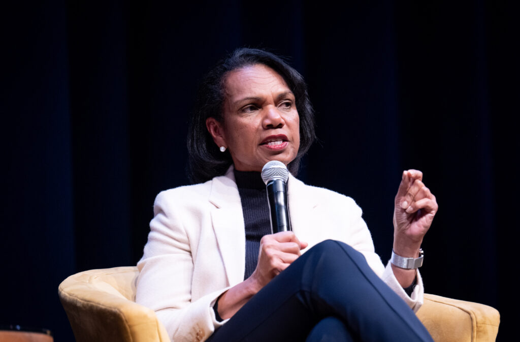 Condoleezza Rice speaking into a microphone while looking into the audience