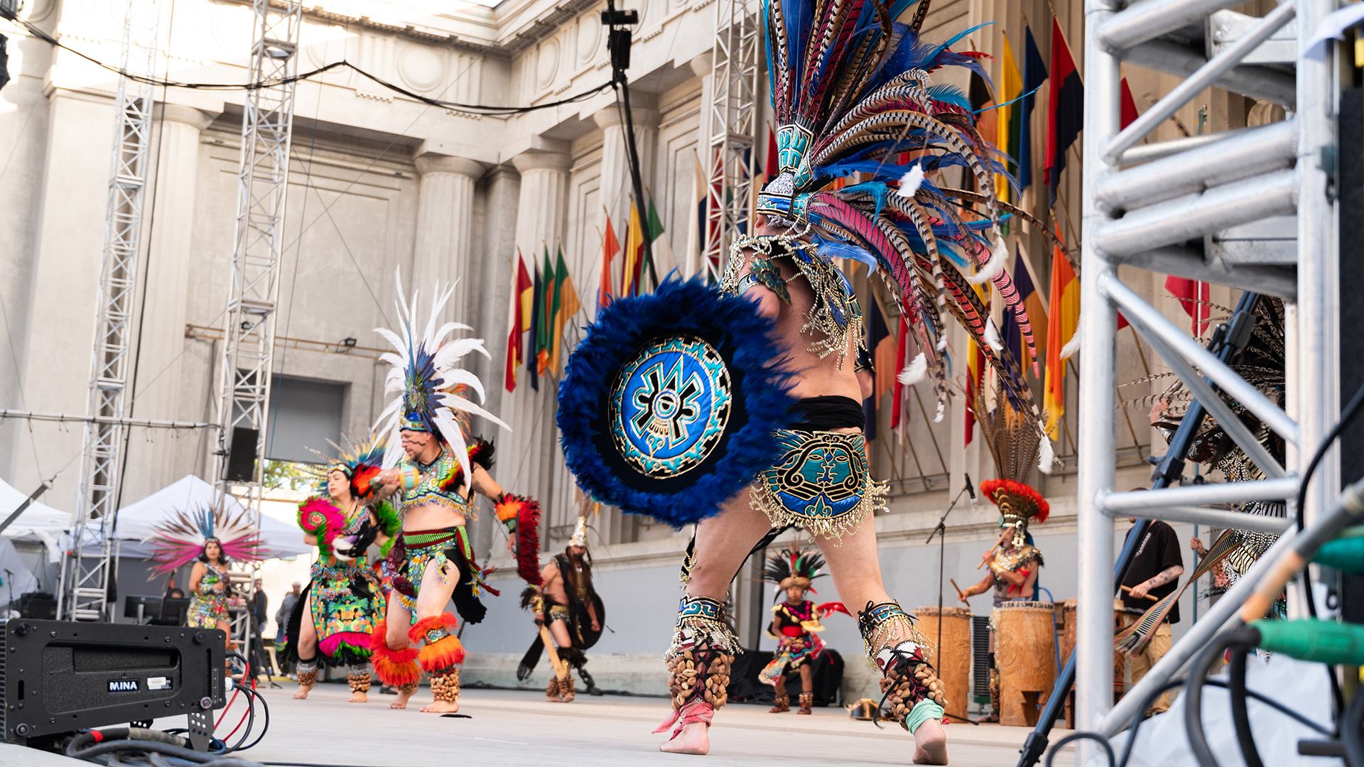 Dancers with Mexican Indigenous roots perform on stage during a graduation ceremony