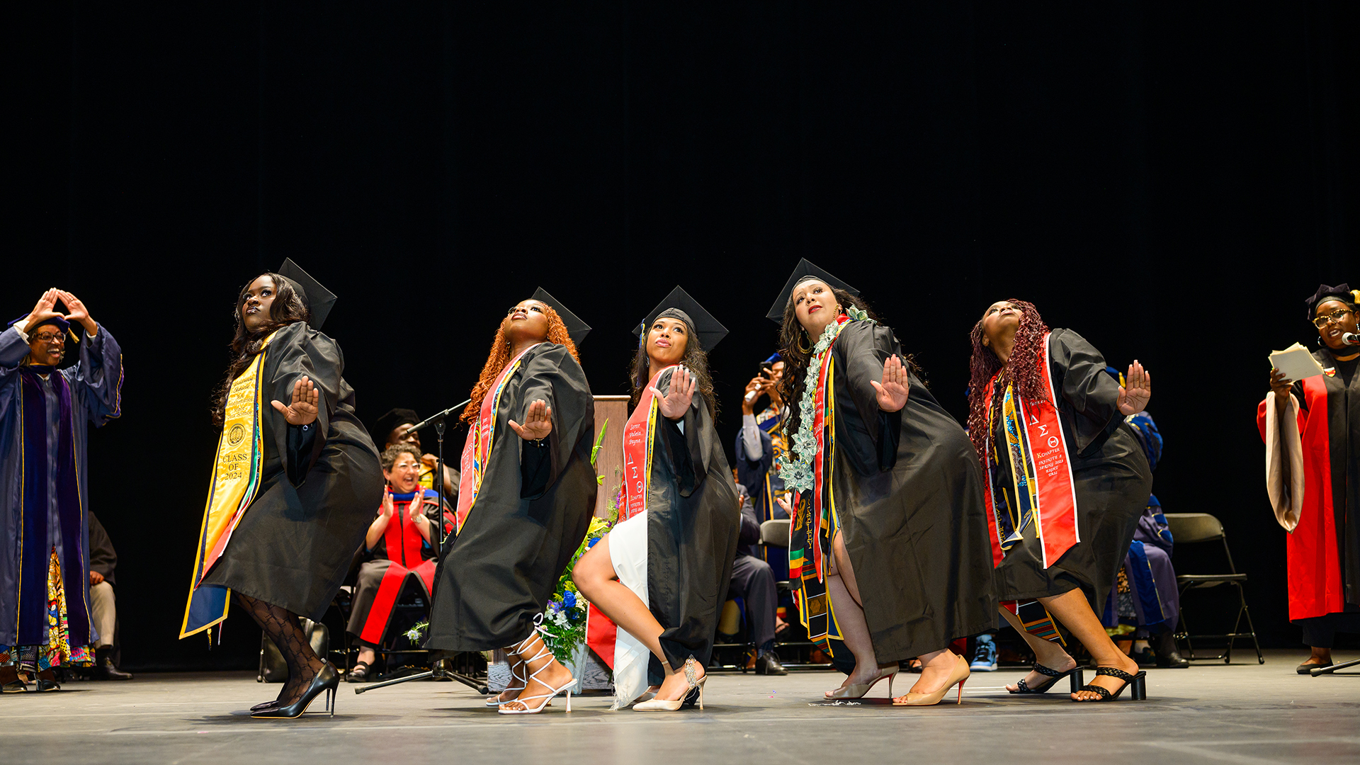 Graduating students at the Black graduation ceremony dance on stage