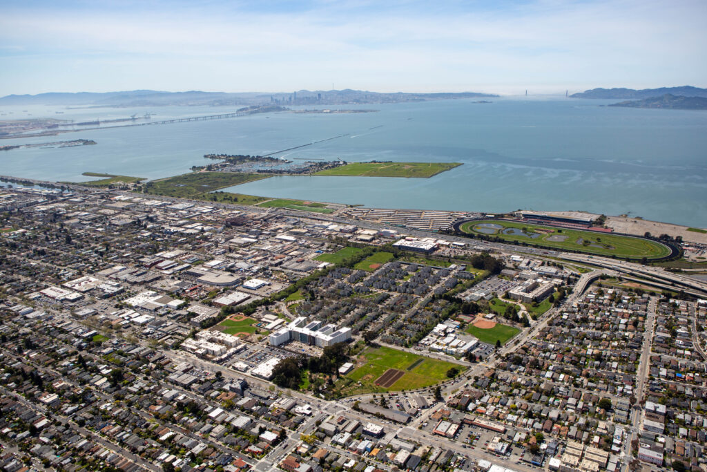 An aerial view, taken by drone, of the new graduate student apartments being built in Albany near University Village. San Francisco Bay is in the distance, and the city of Albany, including Golden Gate Fields and the 80 freeway, can be seen around the complex.