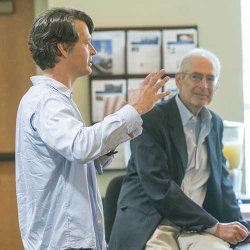 John Hanke speaking in a classroom with Jerom Engel