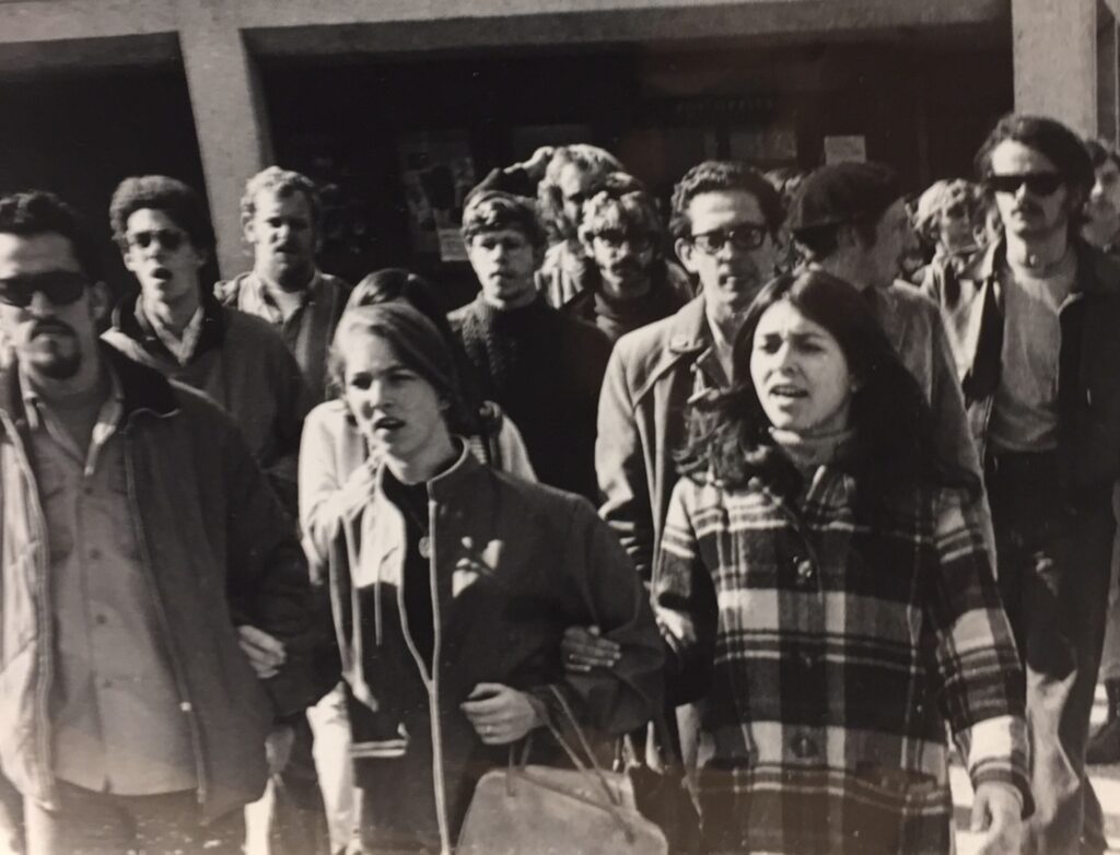 Black and white photo of Clementina Duron and other student TWLF strikers walking out of campus.