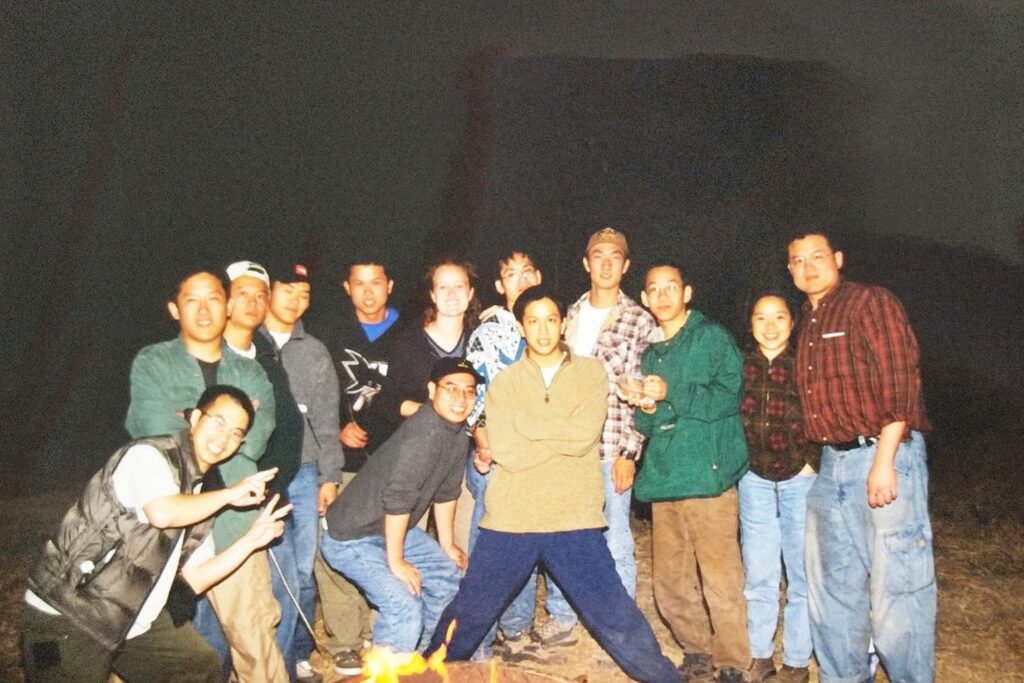 A group of 13 Rotten Tomatoes staffers posing by a bonfire.