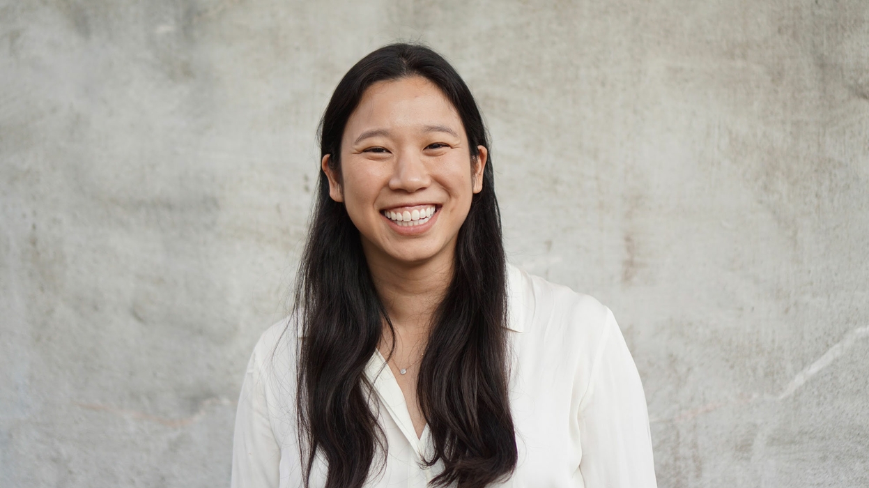 A headshot of Irene Chen, smiling, against a gray background.