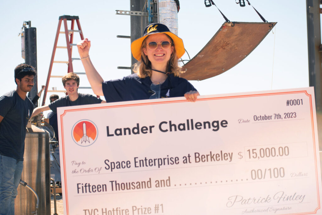 Lilly Eztenbach, at center of photo, holds an oversized check for $15,000 paid to Space Enterprise at Berkeley