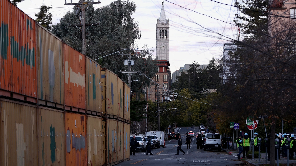 A photo shows double-stacked shipping containers along a Berkeley street, with a view of the Campanile in the background.