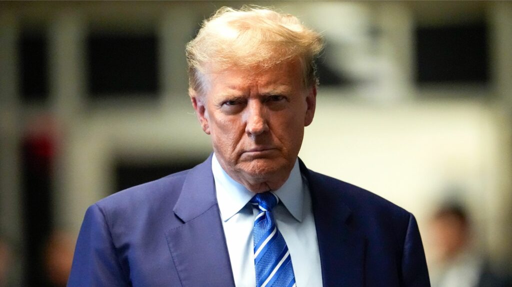 Donald Trump outside of a Manhattan courtroom, in eerie light, his expression stern