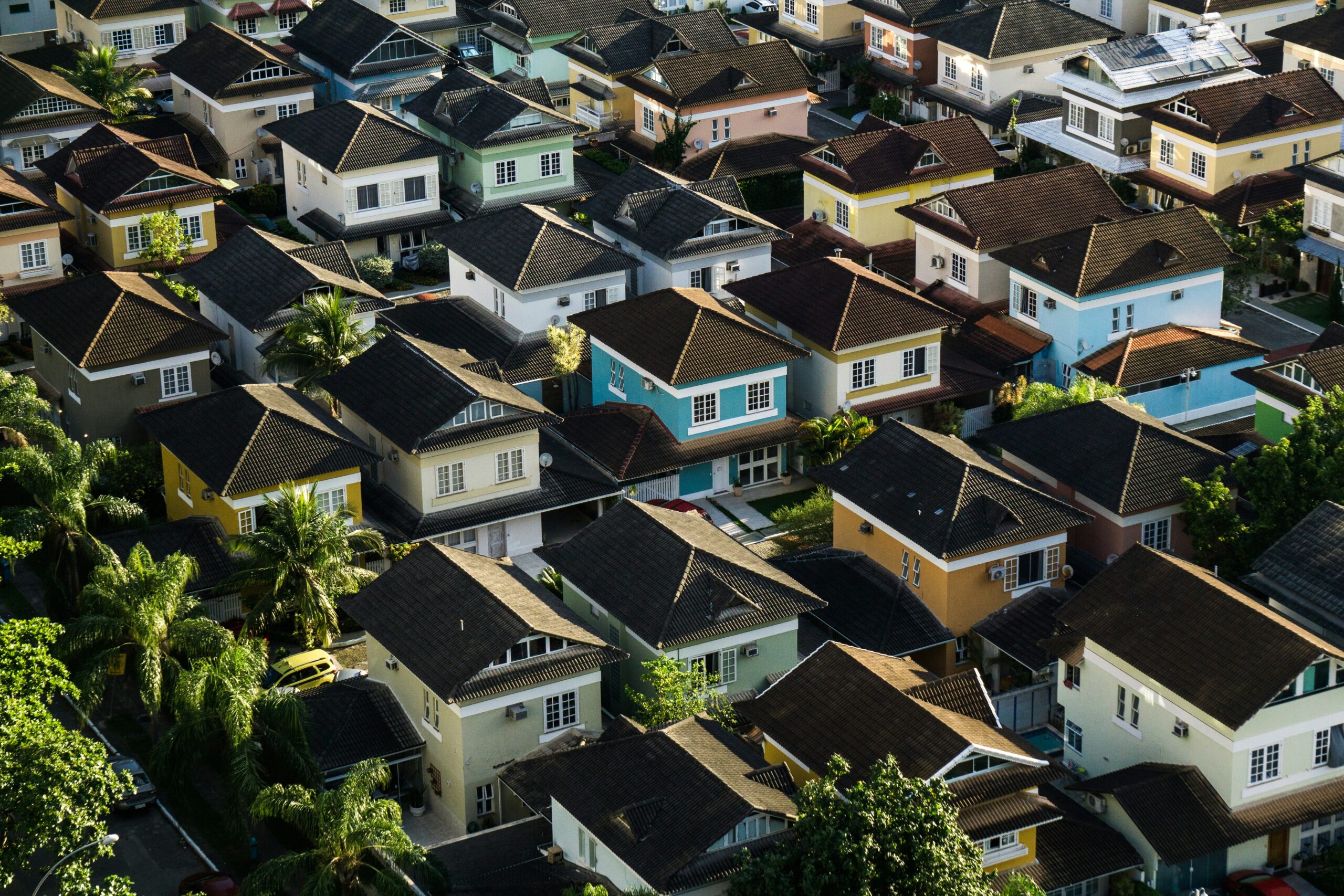 A photo of rows of houses in the suburbs, all painted in different colors.