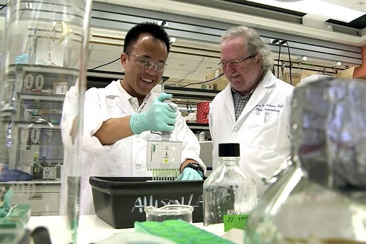 James Allison working in a lab with a student.