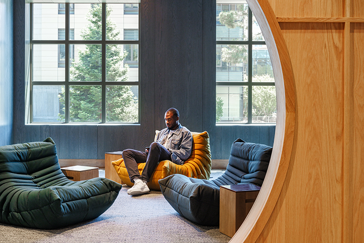 A space in Anchor House called The Hideway is accessed through a circular entrance under a stairway. The space has comfortable seating for students to sit, relax or read.