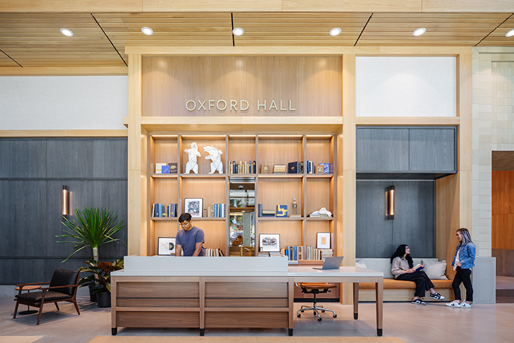 Oxford Hall, inside the main entrance of Anchor House, features benches and chairs to rest on and a large bookshelf filled with art objects and books that evoke campus history, including Blue & Gold yearbooks and a set of origami bears.