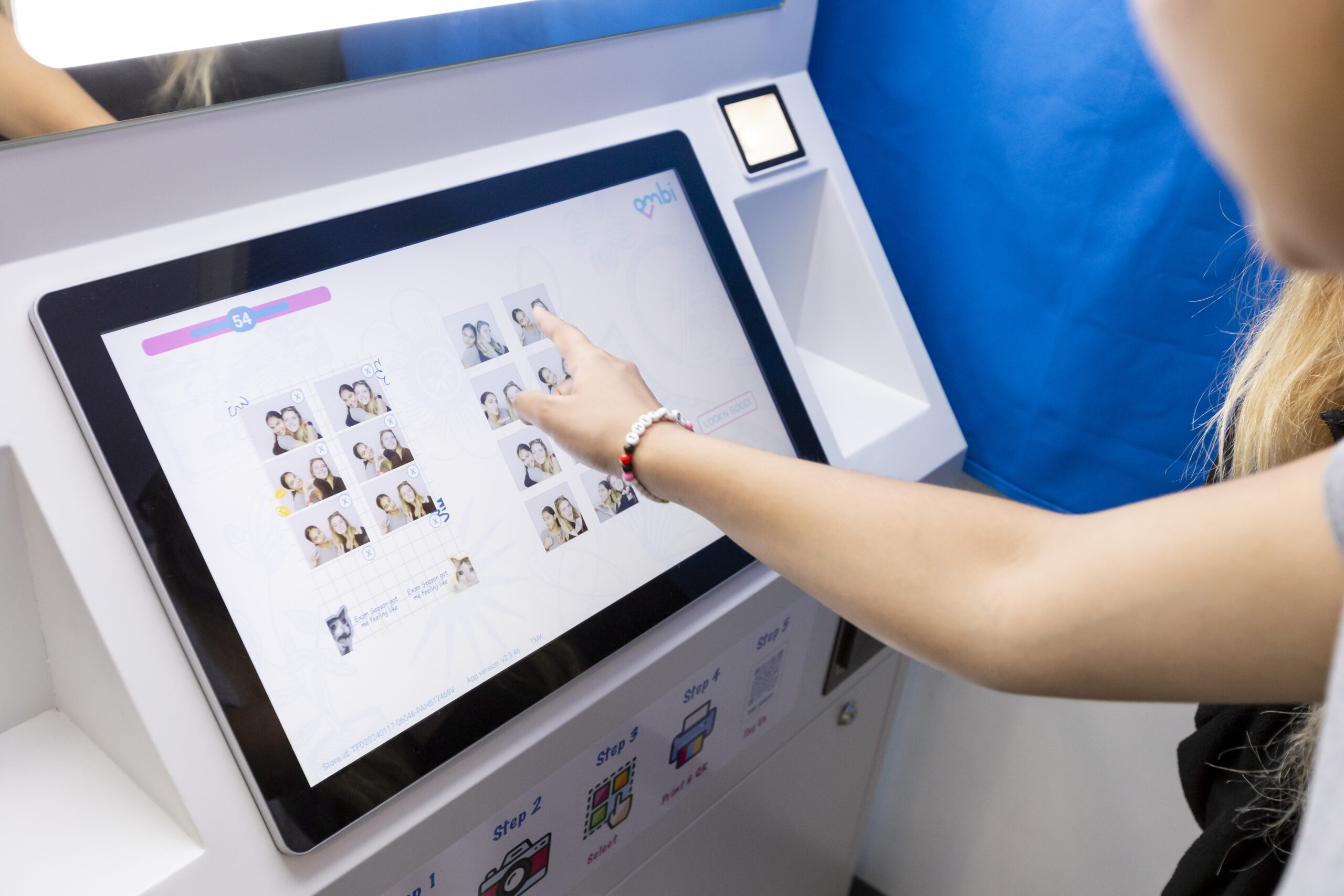 A student in one of the new photo booths in the student union makes her selection on a screen inside the booth that offers different frames and other customizable options for photos.