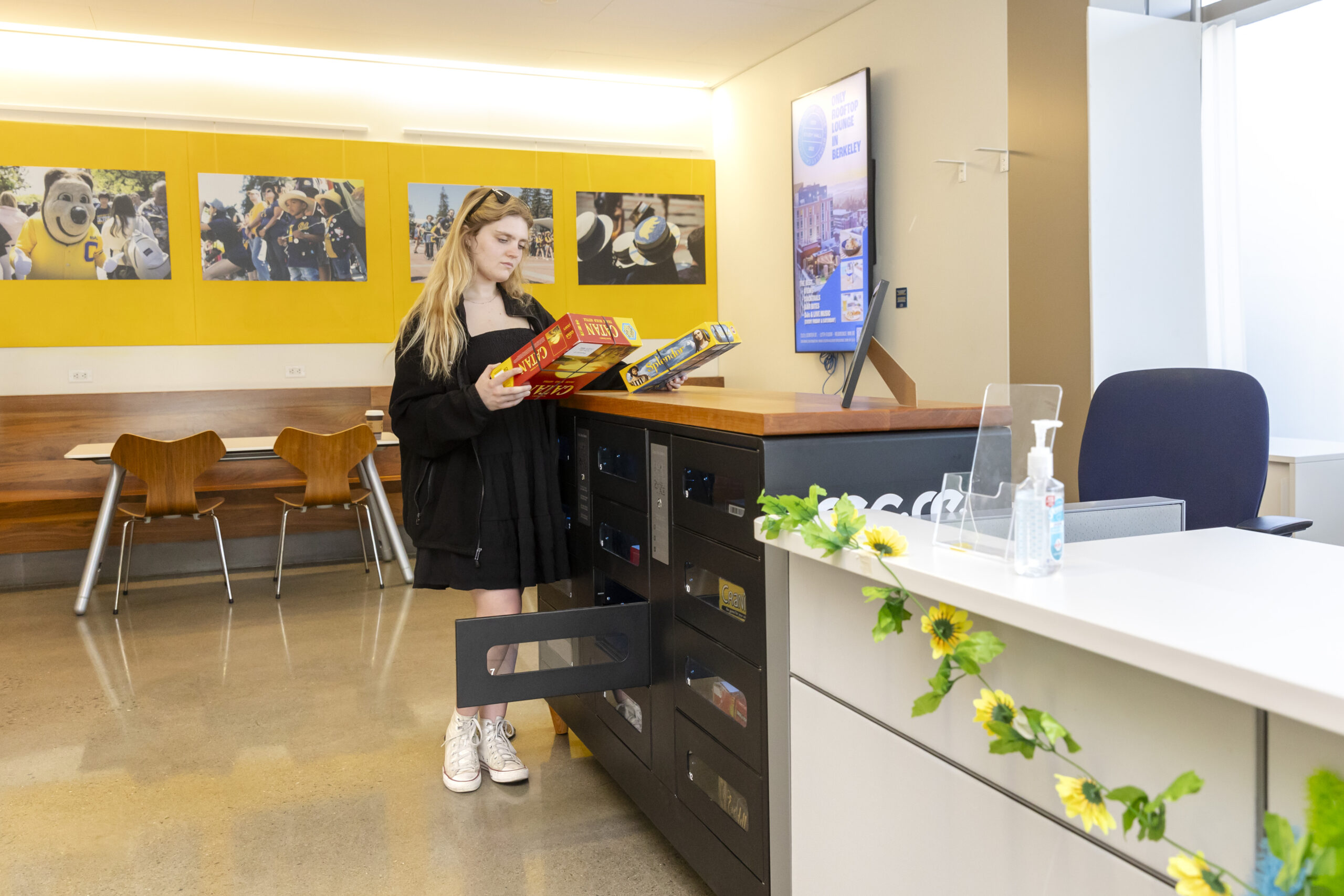 A student looks at two different board games at a new RecRe box at the MLK Jr. Building of the student union. The box — one of 5 offered on campus by the ASUC — is filled with games, including ping pong paddles and balls, that can be rented for free for a certain length of time.